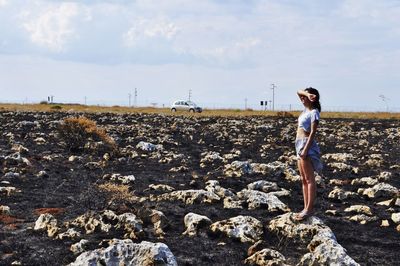 Woman standing on field against sky