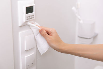 Cropped hand of person cleaning switchboard