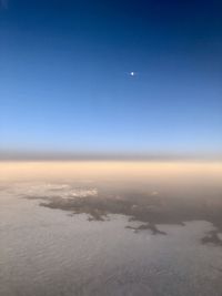 Scenic view of snow covered landscape against clear blue sky