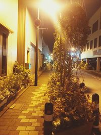 Illuminated street amidst buildings at night