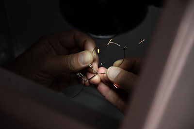 Cropped hand of person holding broken eyeglasses