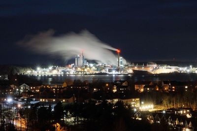 Illuminated city against sky at night