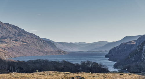 Scenic view of land and mountains against clear sky