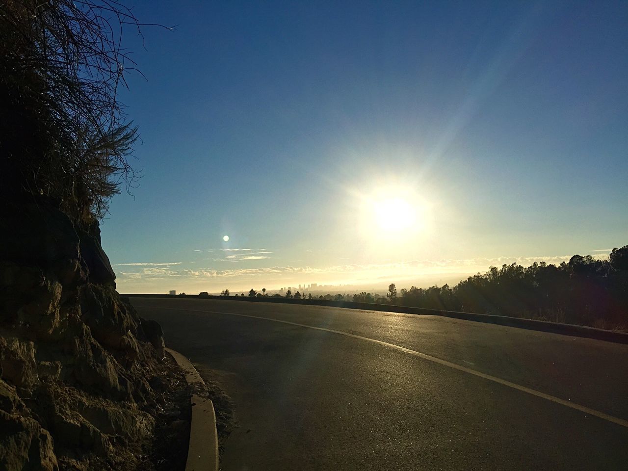 sun, sunlight, clear sky, tranquility, tranquil scene, road, sunbeam, scenics, lens flare, nature, beauty in nature, blue, the way forward, sky, landscape, copy space, transportation, tree, sunny, outdoors