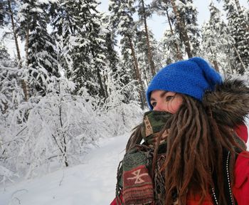Close-up portrait of young woman standing in snow