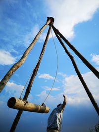 Low angle view of man standing at chain swing ride