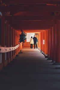 Rear view of people walking in corridor of building