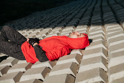 Young man in red hoodie. lying under the sun. unusual texture.