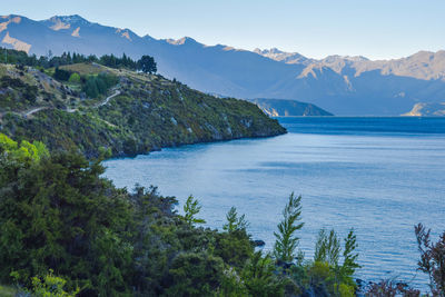 Scenic view of sea and mountains against clear sky