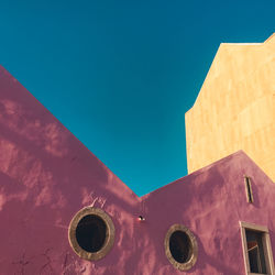 Low angle view of old building against clear blue sky