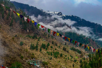 Multi colored flags on mountain against sky