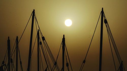 Low angle view of silhouette cranes against sky during sunset