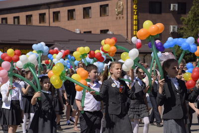 Group of people with balloons in city