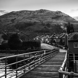 Footbridge over mountains against sky