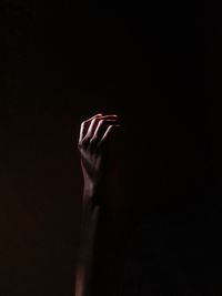 Close-up of hand against black background