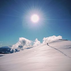 Low angle view of snow covered mountain against blue sky