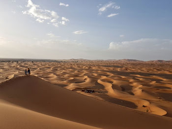 High angle view of friends on sand dune against sky