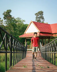 Full length of woman standing on footbridge