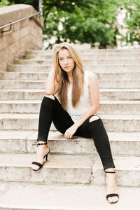 Portrait of young woman sitting on staircase
