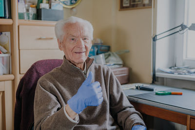 Portrait of woman sitting on table at home