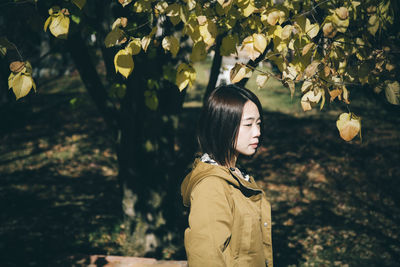 Rear view of woman standing against plants