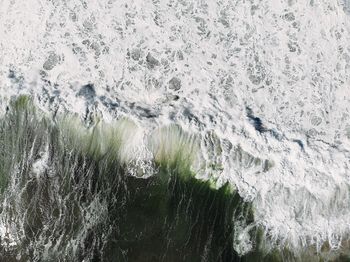 High angle view of sea waves splashing on rocks