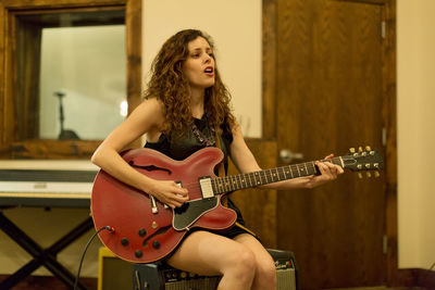 Young woman playing an electric guitar