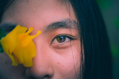 Close-up portrait of woman with red eyes closed