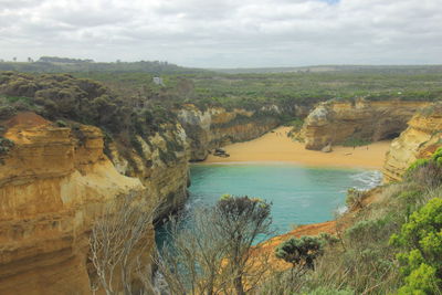 Scenic view of cliff and sea against sky