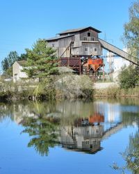 Building by lake against clear sky