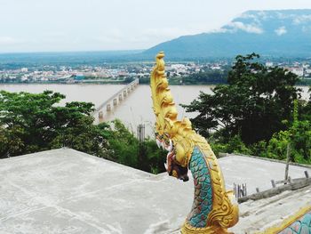 Close-up of statue by sea against sky