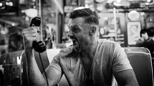 Man screaming while holding telephone receiver