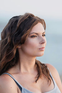 Close-up of young woman against sky