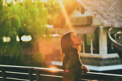 Side view of woman looking away at railing