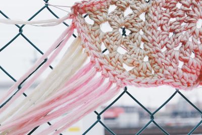 Close-up of decoration hanging against fence