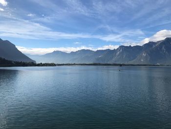 Scenic view of lake by mountains against sky