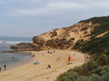 People on beach against sky