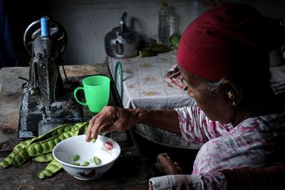 Portrait of woman holding food on table at home