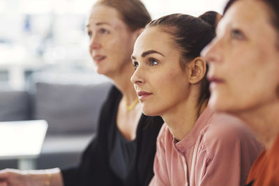 Concentrated businesswomen listening in meeting at office