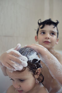 Brothers bathing and playing with foam