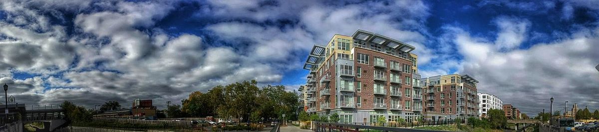 Low angle view of buildings against cloudy sky