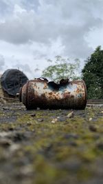 Old rusty metal on land against sky