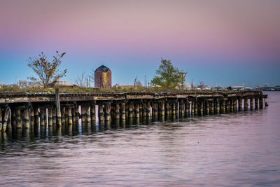 Bridge over river against sky at sunset