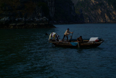 People on rowboat sailing in sea
