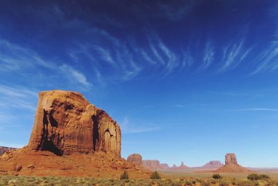 Rock formations on landscape against cloudy sky