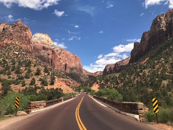 Road by mountains against sky