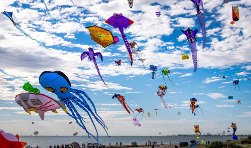 Low angle view of umbrellas hanging on beach against sky