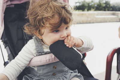 Portrait of cute girl sitting outdoors