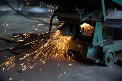 Welder used grinding stone on steel in factory with sparks, welding process at the industrial work