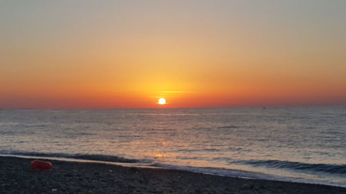 Scenic view of sea against orange sky